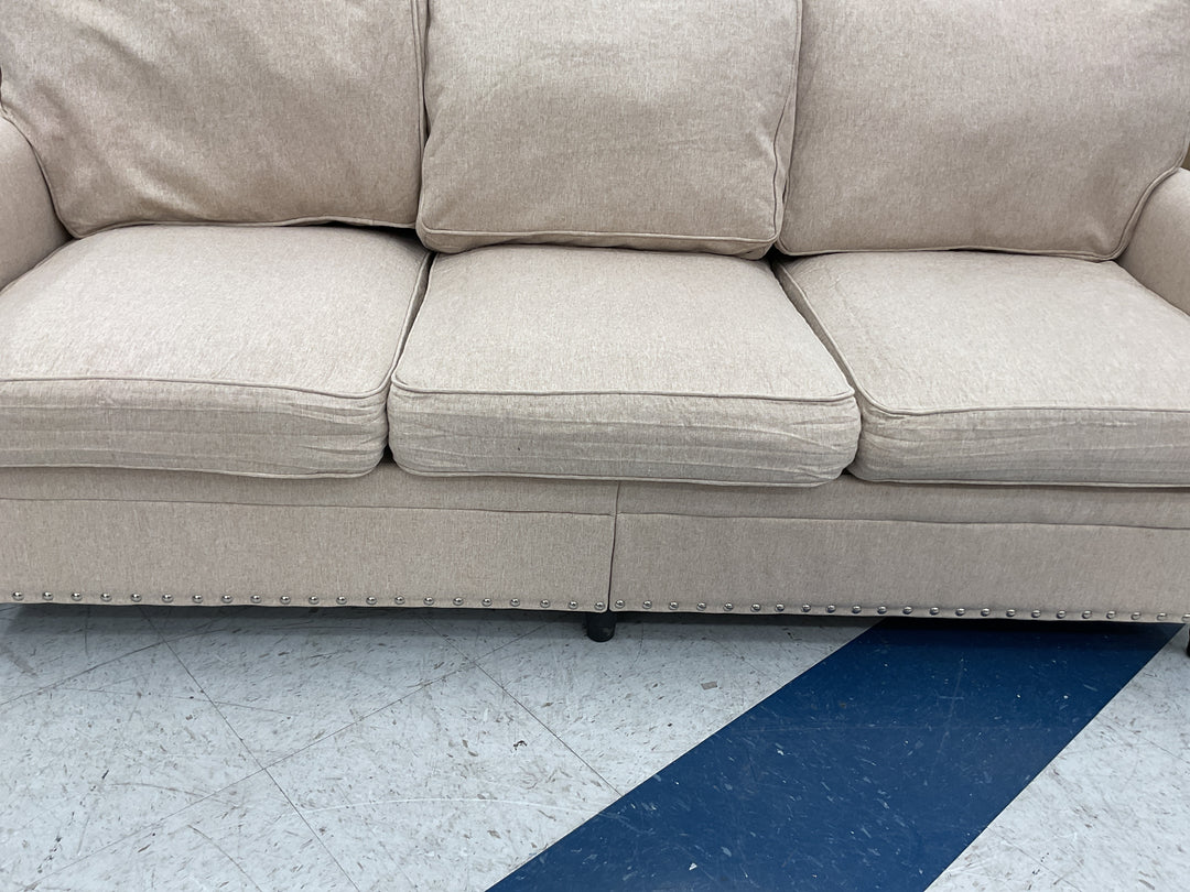 Beige three-cushion fabric sofa, silver nailhead trim, Retail $450