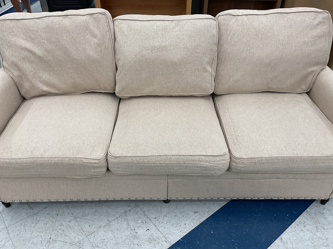 Beige three-cushion fabric sofa, silver nailhead trim, Retail $450